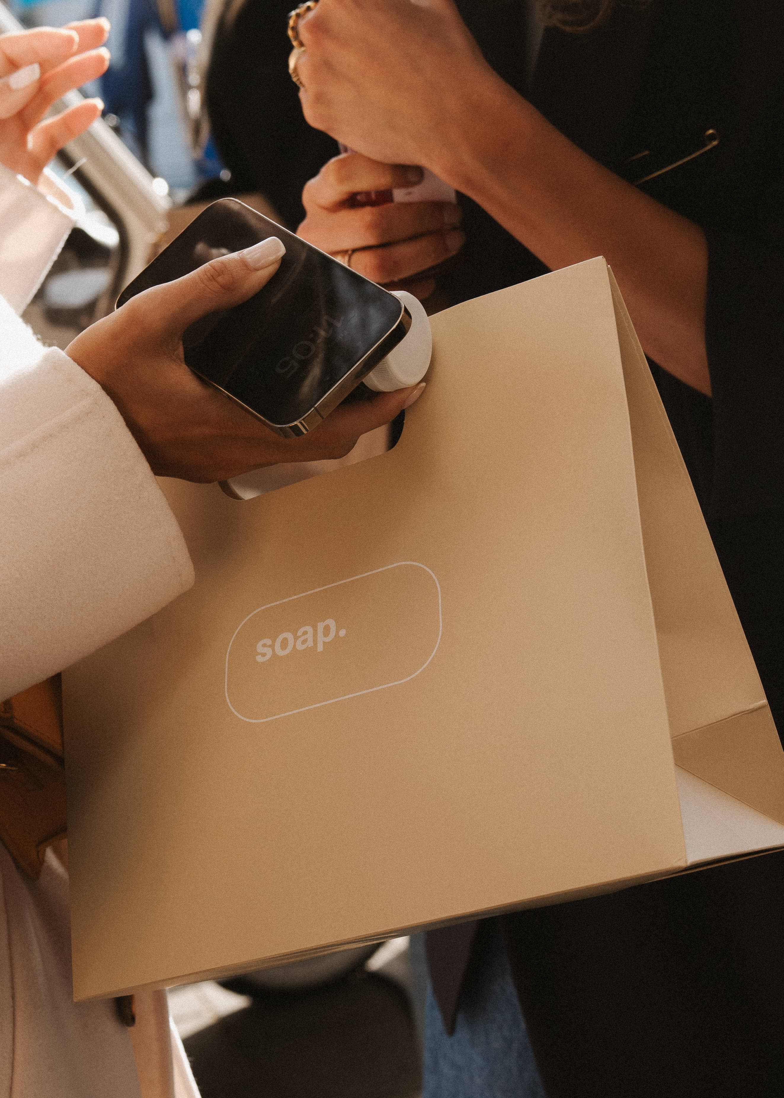 Twee handen houden een tas van Soap en een klein product vast