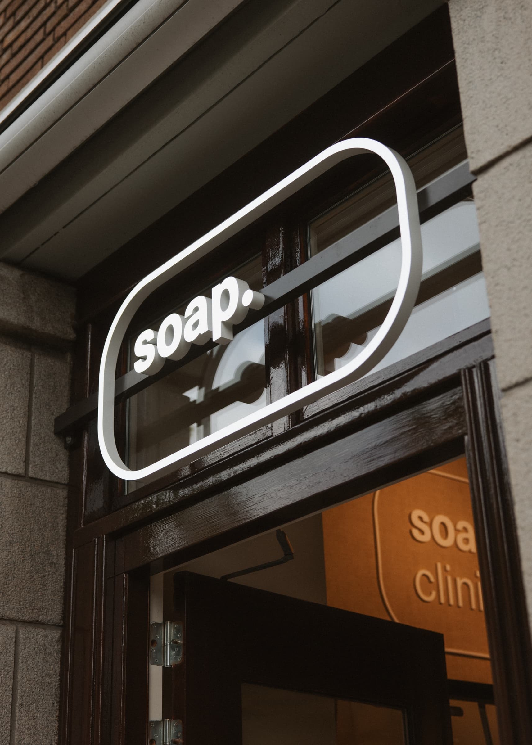 Het verlichte soap.-logo boven de ingang van een Soap store