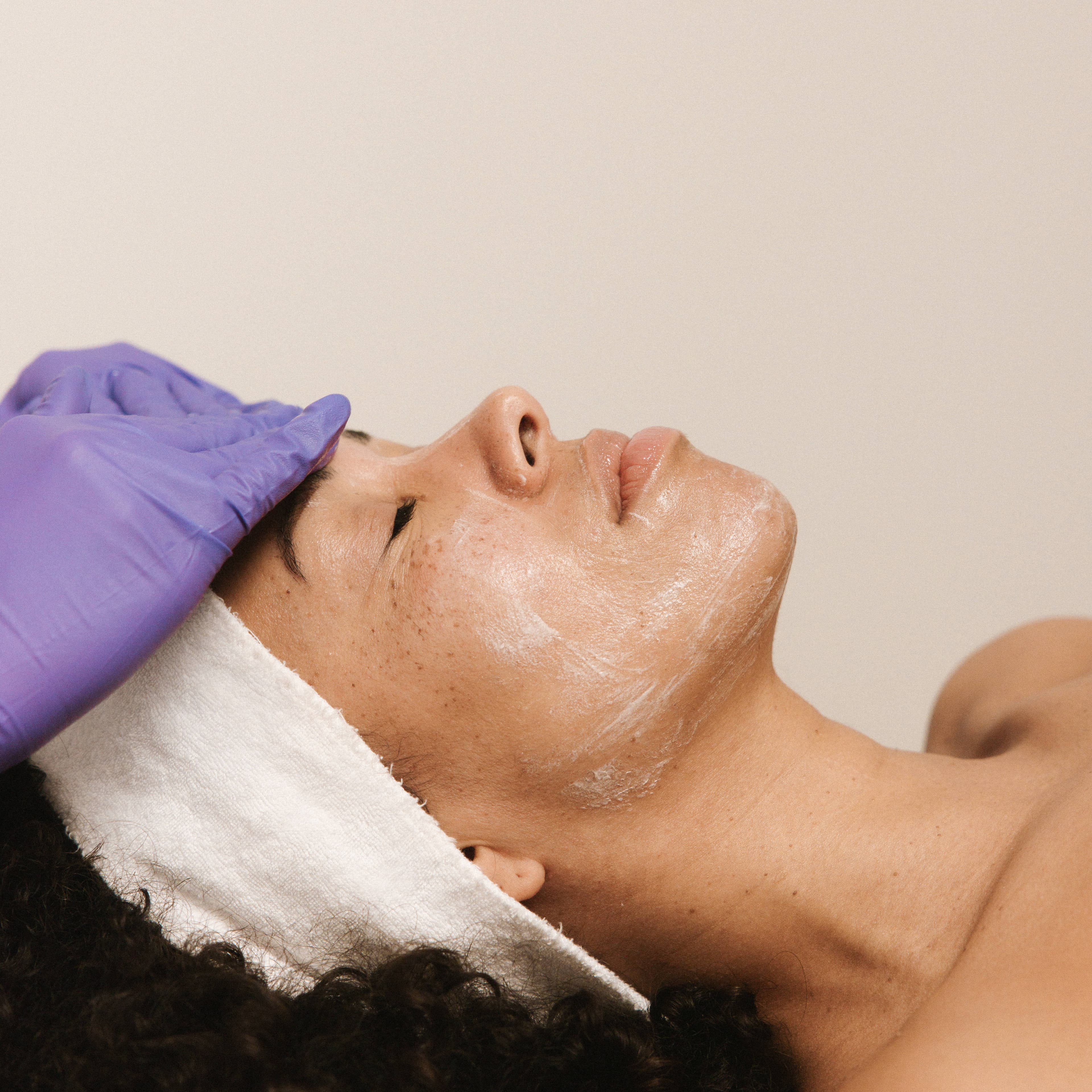 Huidtherapeut brengt een masker aan tijdens een facial, gezichtsbehandeling Den Haag